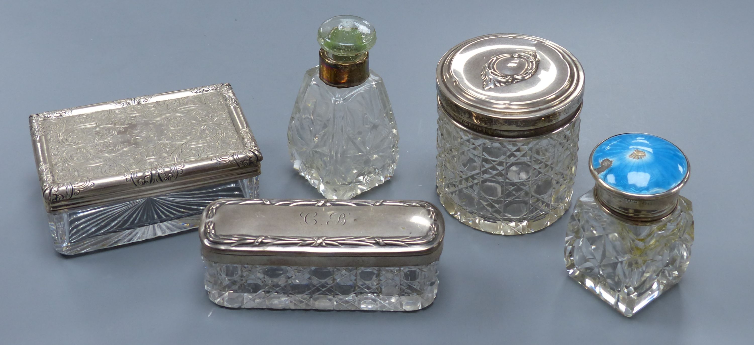 A Victorian silver mounted glass toilet jar, 98mm, four other silver mounted toilet jars, including one with enamel(a.f.).
